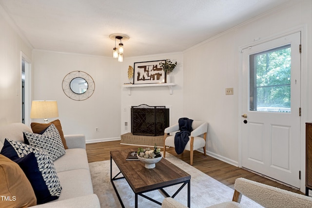 1416 Bramble Dr, Durham, NC 27712 - living area featuring wood finished floors, crown molding, a brick fireplace, and baseboards