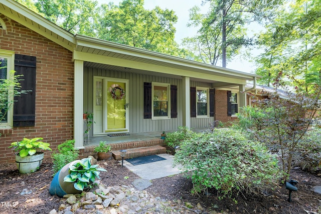 1416 Bramble Dr, Durham, NC 27712 - doorway to property with a porch, brick siding, and board and batten siding