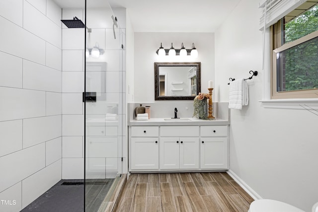 1416 Bramble Dr, Durham, NC 27712 - bathroom featuring walk in shower, vanity, wood finish floors, and toilet