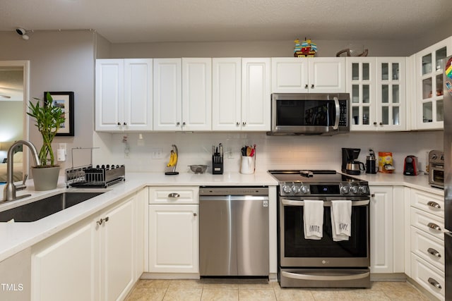 1911 Falls Landing Dr Unit 103, Raleigh, NC 27614 - kitchen featuring appliances with stainless steel finishes, a sink, decorative backsplash, and white cabinetry