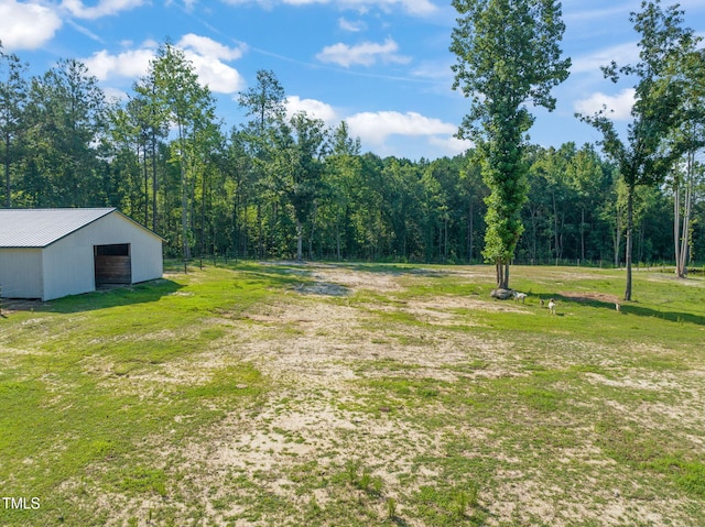 80 Shartree Farms Ln, Louisburg, NC 27549 - view of grassy yard featuring a pole building, a view of trees, an outbuilding, and a detached garage