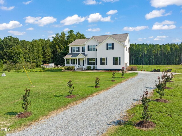 80 Shartree Farms Ln, Louisburg, NC 27549 - colonial inspired home with gravel driveway, a wooded view, a front yard, and covered porch