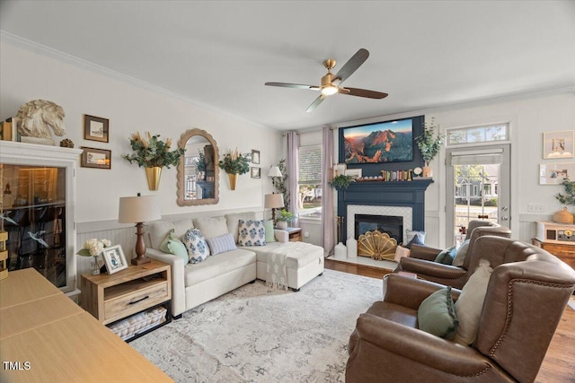 817 Mossy Oak Dr, Fuquay Varina, NC 27526 - living room with a fireplace with flush hearth, crown molding, a ceiling fan, wood finished floors, and a wainscoted wall
