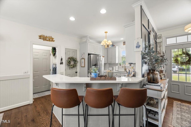 817 Mossy Oak Dr, Fuquay Varina, NC 27526 - kitchen featuring stainless steel fridge, ornamental molding, dark wood-style flooring, light countertops, and a peninsula