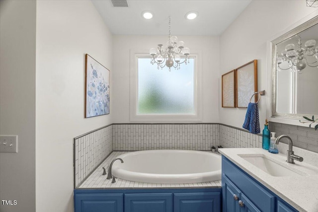 817 Mossy Oak Dr, Fuquay Varina, NC 27526 - bathroom featuring a chandelier, vanity, a garden tub, and recessed lighting