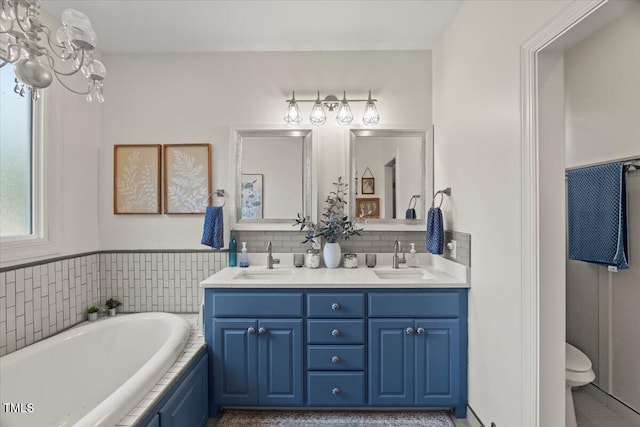 817 Mossy Oak Dr, Fuquay Varina, NC 27526 - full bath with double vanity, a bath, toilet, and a chandelier