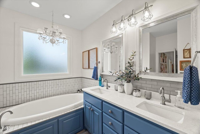 817 Mossy Oak Dr, Fuquay Varina, NC 27526 - bathroom featuring double vanity, a garden tub, a chandelier, and tasteful backsplash