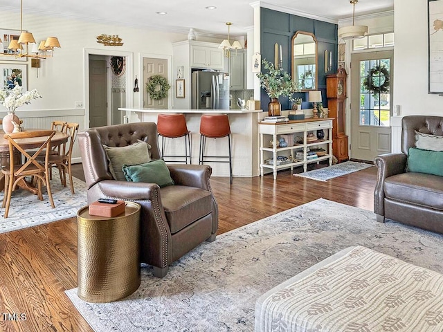 817 Mossy Oak Dr, Fuquay Varina, NC 27526 - living area featuring wood finished floors, crown molding, wainscoting, and a chandelier