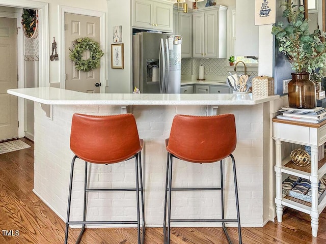 817 Mossy Oak Dr, Fuquay Varina, NC 27526 - kitchen with stainless steel refrigerator with ice dispenser, light wood-style flooring, light countertops, and decorative backsplash