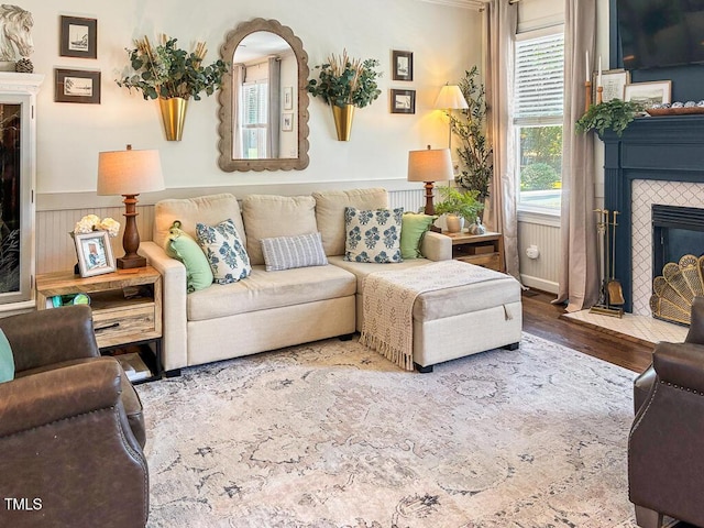 817 Mossy Oak Dr, Fuquay Varina, NC 27526 - living area with a tile fireplace, wood finished floors, and a wainscoted wall