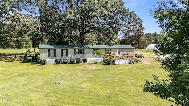 1355 Sykes Rd, Spring Hope, NC 27882 - manufactured / mobile home with a front yard, a wooden deck, and view of scattered trees