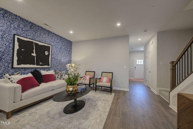 1227 Bessie Ct, Wake Forest, NC 27587 - living area featuring wood finished floors, wallpapered walls, stairway, baseboards, and an accent wall