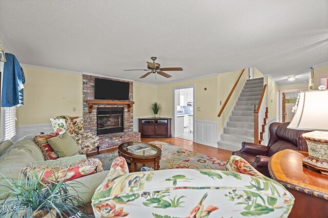 2000 Glissom St, Tarboro, NC 27886 - living area featuring a textured ceiling, a wainscoted wall, wood finished floors, stairs, and ceiling fan