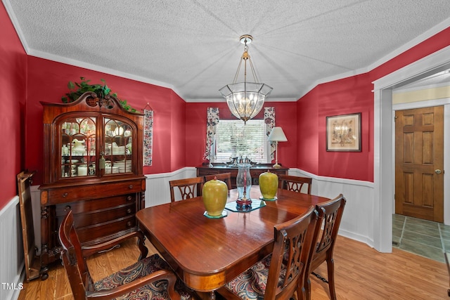 2000 Glissom St, Tarboro, NC 27886 - dining space with a chandelier, wainscoting, a textured ceiling, wood finished floors, and ornamental molding