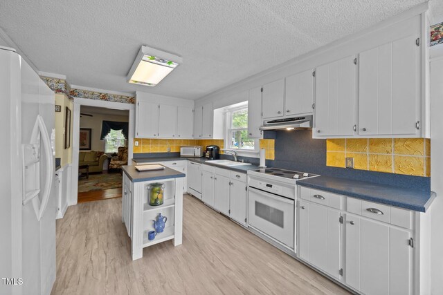 2000 Glissom St, Tarboro, NC 27886 - kitchen featuring white appliances, under cabinet range hood, dark countertops, open shelves, and white cabinetry