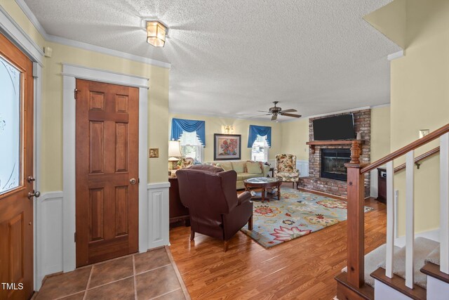 2000 Glissom St, Tarboro, NC 27886 - living room with a ceiling fan, stairway, a brick fireplace, wood finished floors, and a textured ceiling