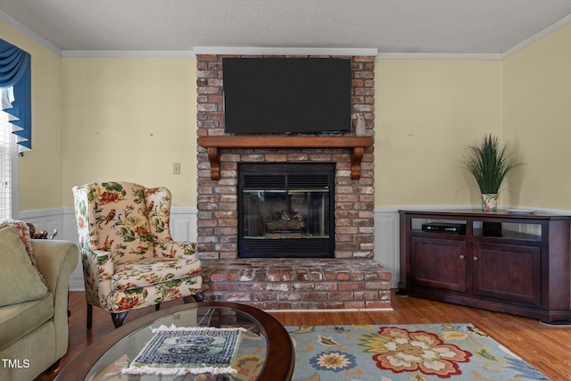 2000 Glissom St, Tarboro, NC 27886 - living area featuring wood finished floors, a fireplace, crown molding, a wainscoted wall, and a textured ceiling