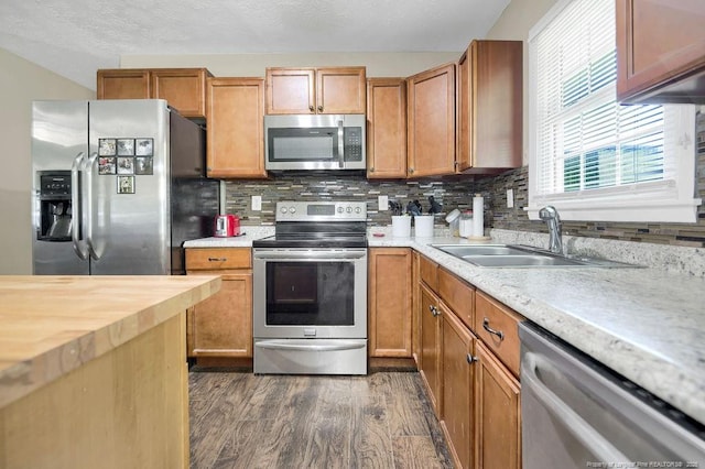 6582 Vineyard Dr, Fayetteville, NC 28304 - kitchen featuring stainless steel appliances, a sink, dark wood finished floors, decorative backsplash, and wood counters