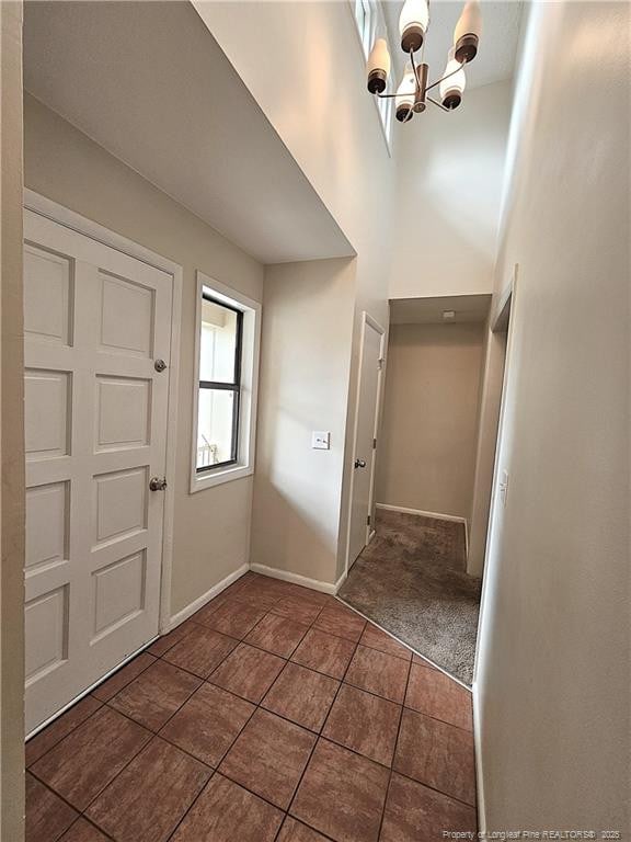 918 Dandridge Dr, Fayetteville, NC 28303 - foyer with dark tile patterned floors, a chandelier, baseboards, and a towering ceiling