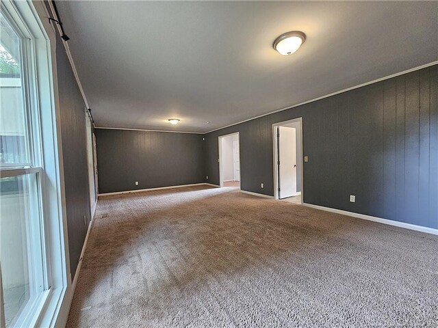 918 Dandridge Dr, Fayetteville, NC 28303 - carpeted empty room featuring a barn door, wooden walls, baseboards, and ornamental molding