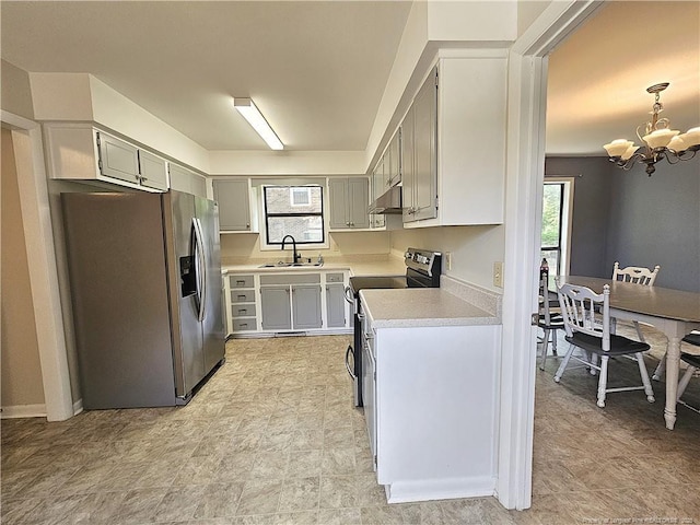 918 Dandridge Dr, Fayetteville, NC 28303 - kitchen with stainless steel appliances, a sink, a chandelier, light countertops, and under cabinet range hood