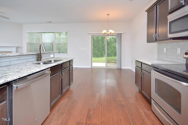 321 Westgrove Ct, Durham, NC 27703 - kitchen featuring appliances with stainless steel finishes, dark brown cabinets, a chandelier, and wood finished floors