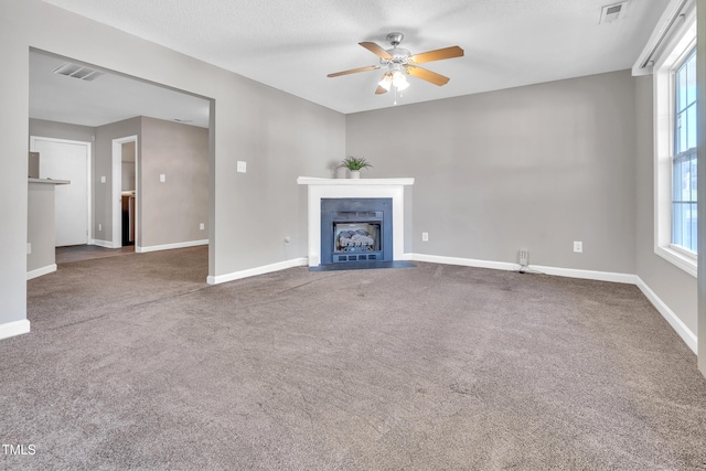 5617 Tealbrook Dr, Raleigh, NC 27610 - unfurnished living room with a fireplace with flush hearth, ceiling fan, carpet, and plenty of natural light