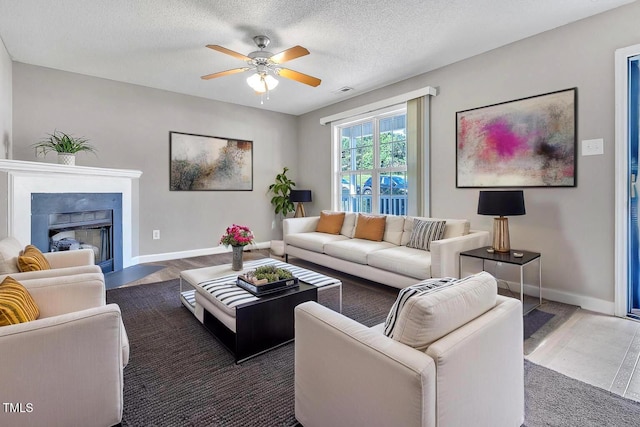 5617 Tealbrook Dr, Raleigh, NC 27610 - living area featuring a ceiling fan, a fireplace with flush hearth, and a textured ceiling