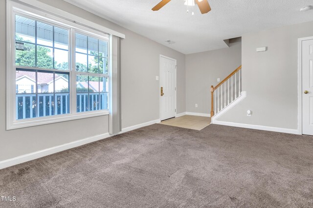 5617 Tealbrook Dr, Raleigh, NC 27610 - carpeted foyer featuring a ceiling fan, stairway, and a textured ceiling