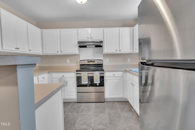 5617 Tealbrook Dr, Raleigh, NC 27610 - kitchen featuring appliances with stainless steel finishes, under cabinet range hood, light countertops, white cabinetry, and a textured ceiling