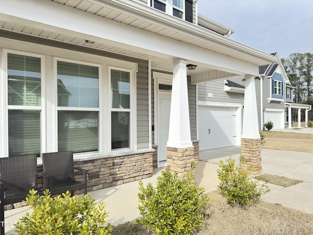 13 Knotty Pine Ln, Clayton, NC 27520 - doorway to property featuring a garage, stone siding, a porch, and driveway