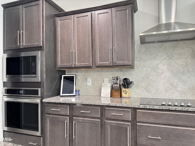 13 Knotty Pine Ln, Clayton, NC 27520 - kitchen featuring stainless steel appliances, wall chimney exhaust hood, dark brown cabinetry, and tasteful backsplash