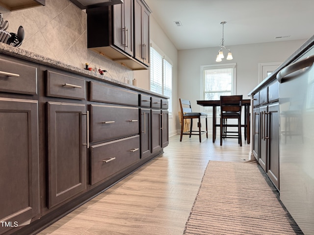13 Knotty Pine Ln, Clayton, NC 27520 - kitchen featuring dark brown cabinetry, light wood finished floors, fridge, backsplash, and decorative light fixtures