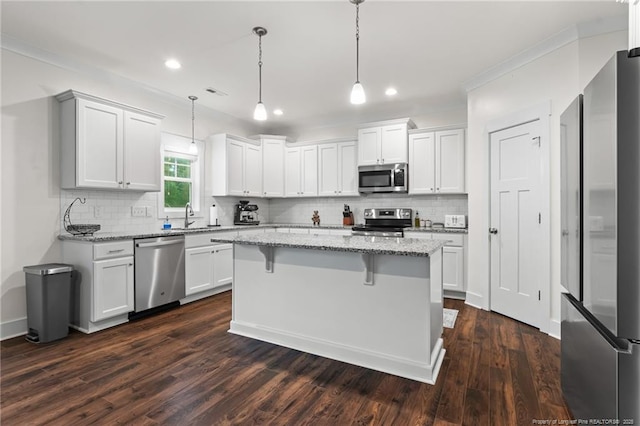 5540 Mountain Run Dr, Hope Mills, NC 28348 - kitchen featuring appliances with stainless steel finishes, decorative backsplash, a kitchen breakfast bar, a sink, and white cabinets