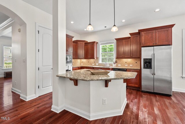 108 Teagan Ct, Chapel Hill, NC 27516 - kitchen with stainless steel appliances, arched walkways, dark wood finished floors, light stone countertops, and recessed lighting