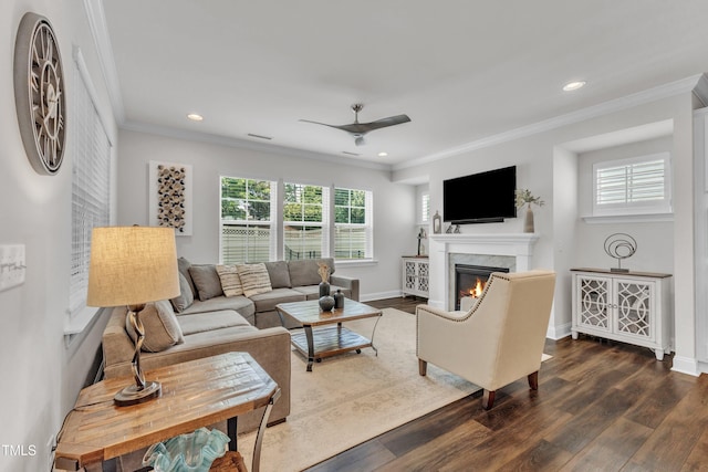 2969 Thirlestane Dr, Apex, NC 27502 - living room with ceiling fan, a warm lit fireplace, dark wood-style flooring, ornamental molding, and recessed lighting