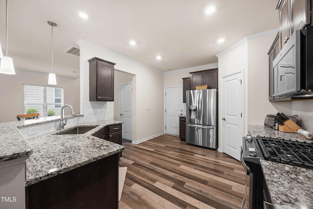 1038 Felman Rd, Durham, NC 27703 - kitchen featuring appliances with stainless steel finishes, ornamental molding, dark brown cabinets, light stone countertops, and dark wood-style flooring