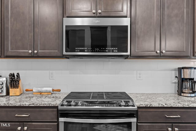 1038 Felman Rd, Durham, NC 27703 - kitchen featuring stainless steel microwave, range with gas cooktop, dark brown cabinets, and tasteful backsplash