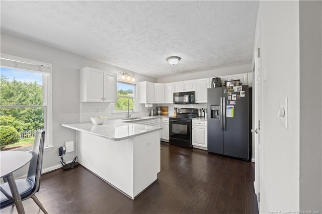 3517 Gables Dr, Fayetteville, NC 28311 - kitchen with black appliances, a sink, a peninsula, white cabinets, and a textured ceiling