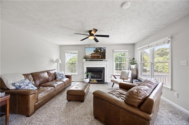 3517 Gables Dr, Fayetteville, NC 28311 - living room with carpet flooring, baseboards, a fireplace with flush hearth, ceiling fan, and a textured ceiling