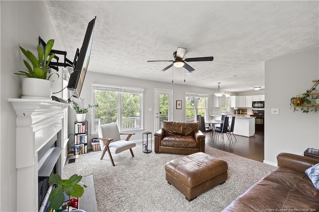 3517 Gables Dr, Fayetteville, NC 28311 - living area featuring a textured ceiling, a ceiling fan, a fireplace with flush hearth, plenty of natural light, and baseboards