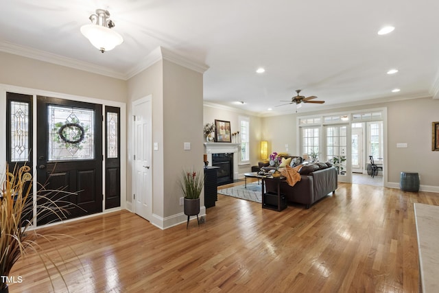 1831 Middlebrook Dr, Raleigh, NC 27615 - foyer featuring light wood finished floors, a glass covered fireplace, recessed lighting, a ceiling fan, and crown molding