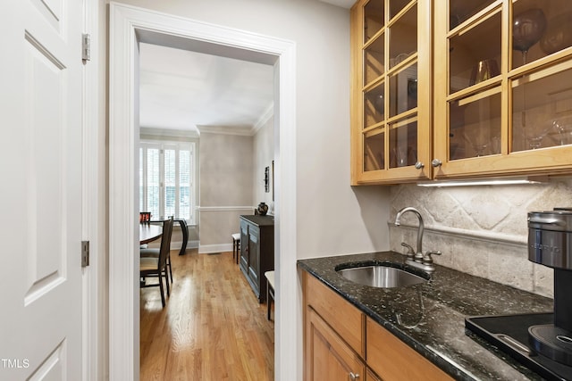 1831 Middlebrook Dr, Raleigh, NC 27615 - kitchen with ornamental molding, decorative backsplash, dark stone counters, light wood-type flooring, and brown cabinetry