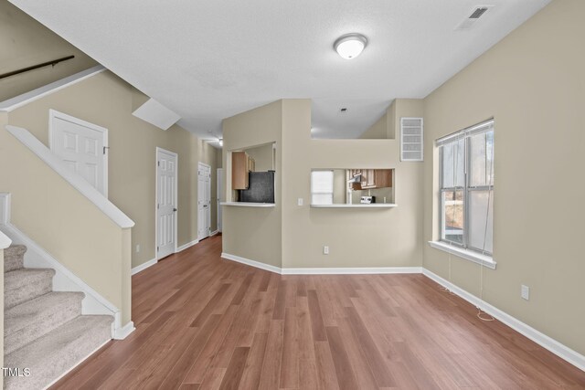 6131 Summerpointe Pl Unit 101, Raleigh, NC 27606 - unfurnished living room with stairway and wood finished floors