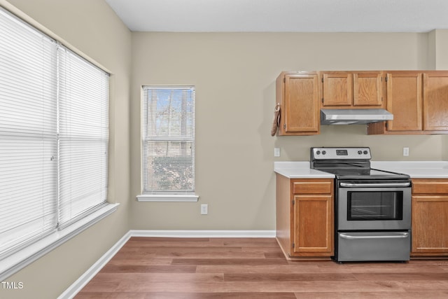 6131 Summerpointe Pl Unit 101, Raleigh, NC 27606 - kitchen featuring stainless steel electric stove, under cabinet range hood, light wood-style floors, and light countertops
