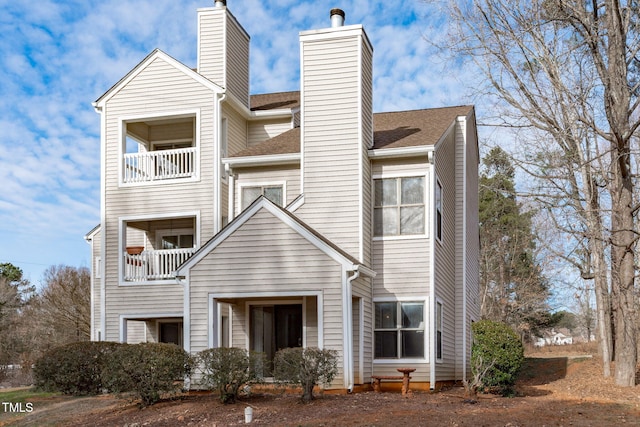 6131 Summerpointe Pl Unit 101, Raleigh, NC 27606 - view of front of home with a chimney, a balcony, and a shingled roof