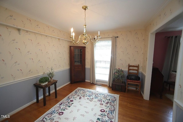 6717 Valley Dr, Raleigh, NC 27612 - dining area featuring a chandelier, crown molding, wood finished floors, wainscoting, and wallpapered walls