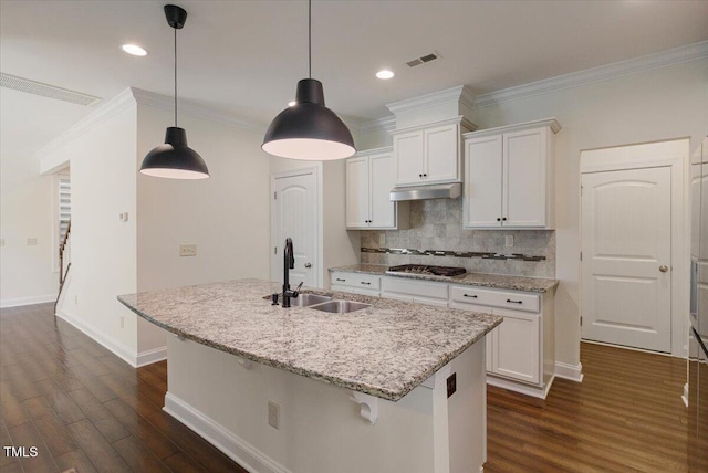 531 Finnbar Dr, Cary, NC 27519 - kitchen with under cabinet range hood, dark wood finished floors, white cabinetry, crown molding, and recessed lighting