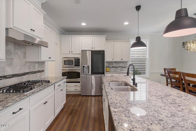 531 Finnbar Dr, Cary, NC 27519 - kitchen with stainless steel appliances, under cabinet range hood, white cabinetry, backsplash, and ornamental molding