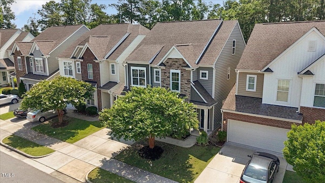 531 Finnbar Dr, Cary, NC 27519 - view of front of house with concrete driveway, an attached garage, roof with shingles, stone siding, and a residential view